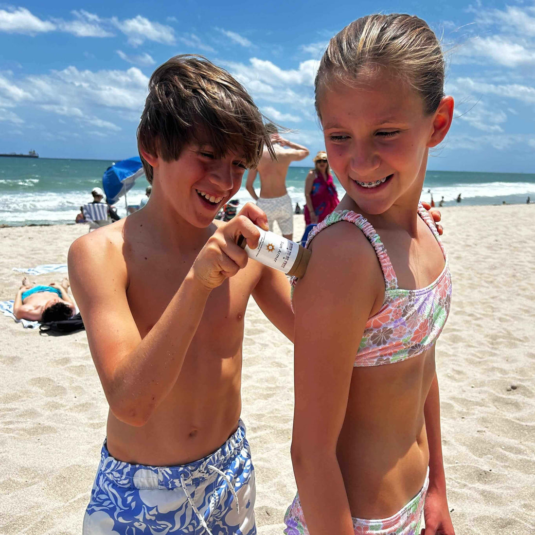 The Dirty Truth About Sunscreen - And What You Should Use Instead: kids applying sunscreen on a beach.