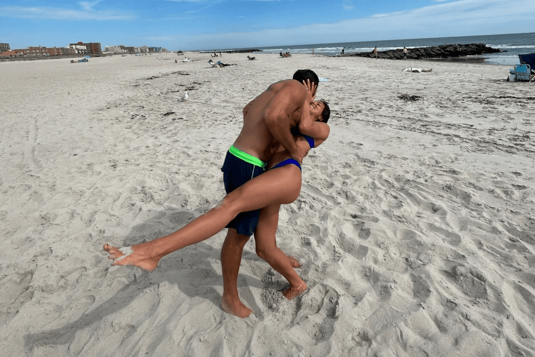 A couple playfully kissing on the beach, symbolizing the joy of connection while trying to reconnect with your inner child.