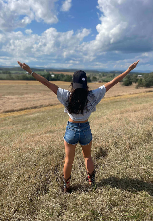 Disconnect to Reconnect- How Nature Improves Mental Health - a woman enjoying nature with arms outstretched in a field.