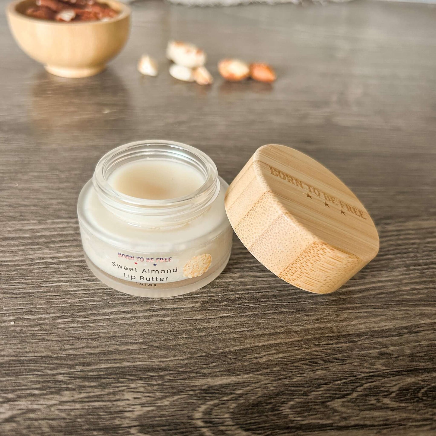 Sweet Almond Lip Butter in a glass jar with a bamboo lid, showcasing its natural, hydrating formula for soft lips.