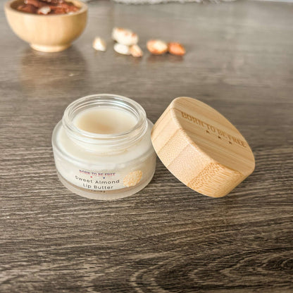 Sweet Almond Lip Butter in a glass jar with a bamboo lid, showcasing its natural, hydrating formula for soft lips.