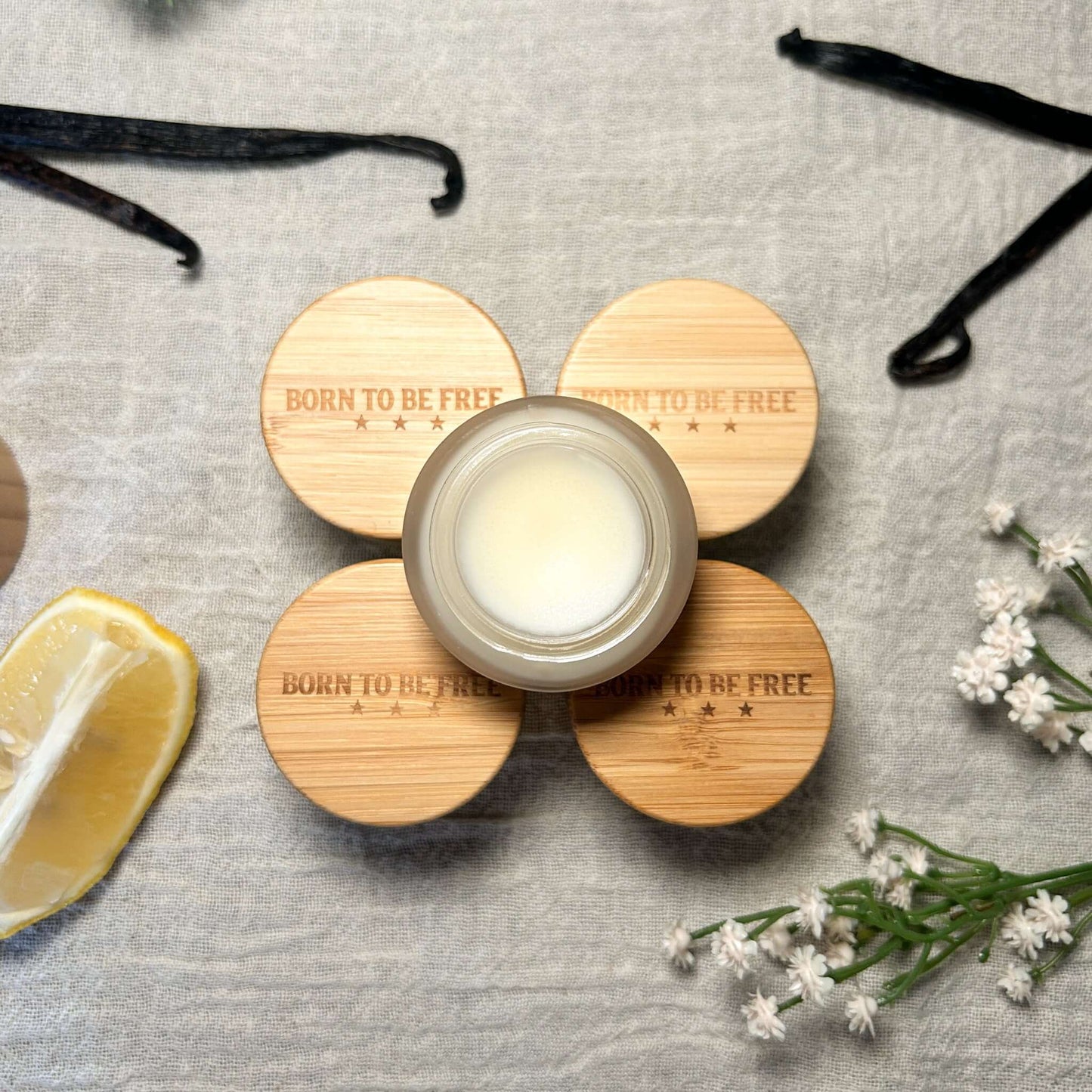 Lip Butter Set displayed with natural ingredients, featuring bamboo lids and a central jar of creamy lip butter.