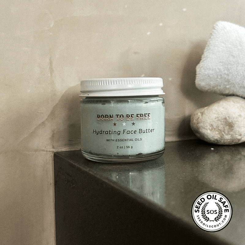 Hydrating Face Butter with Essential Oils in a glass jar on a countertop with towel and soap.