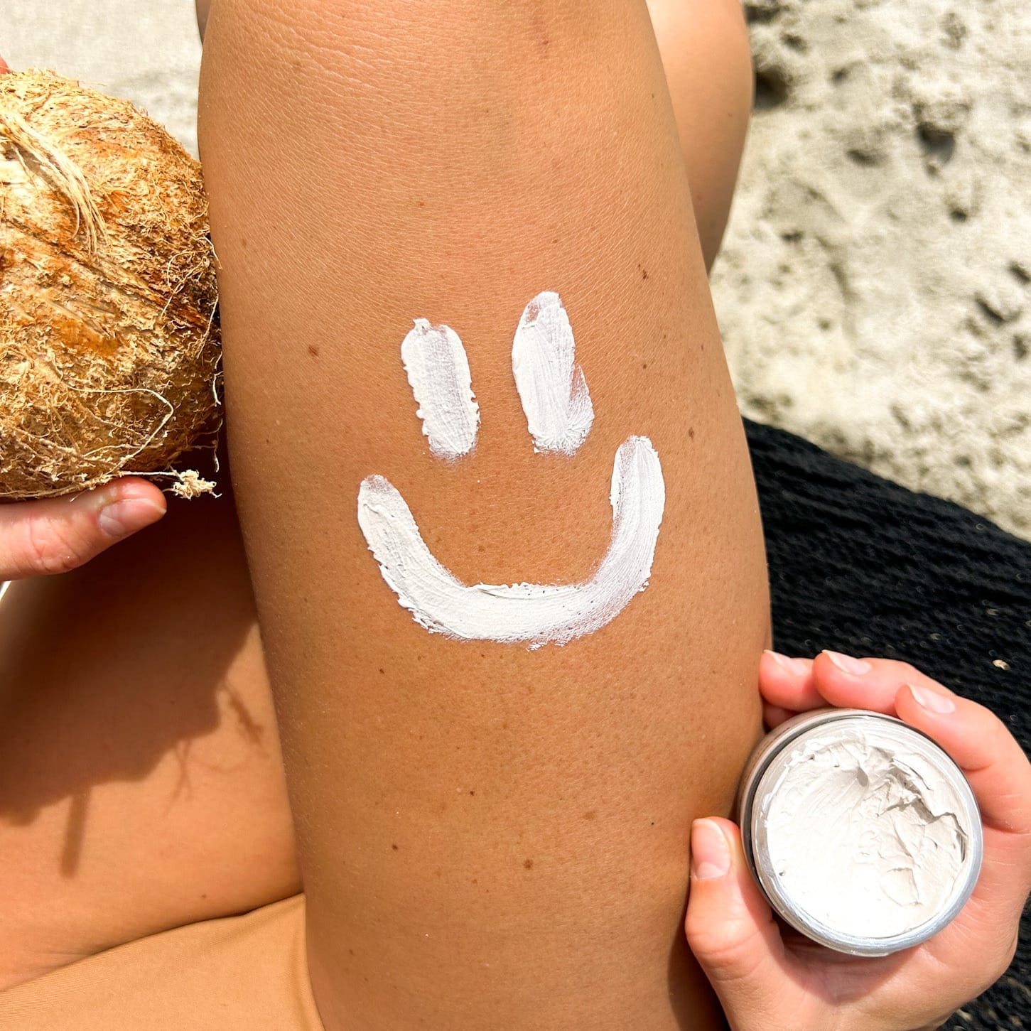 Mineral Based Sun Armor Bundle applied on skin with a smiley face design, showcasing all-natural UV protection.