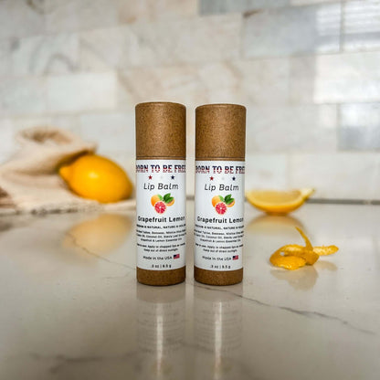 Grapefruit Lemon Lip Balm tubes on countertop with citrus décor, showcasing hydrating natural lip care.