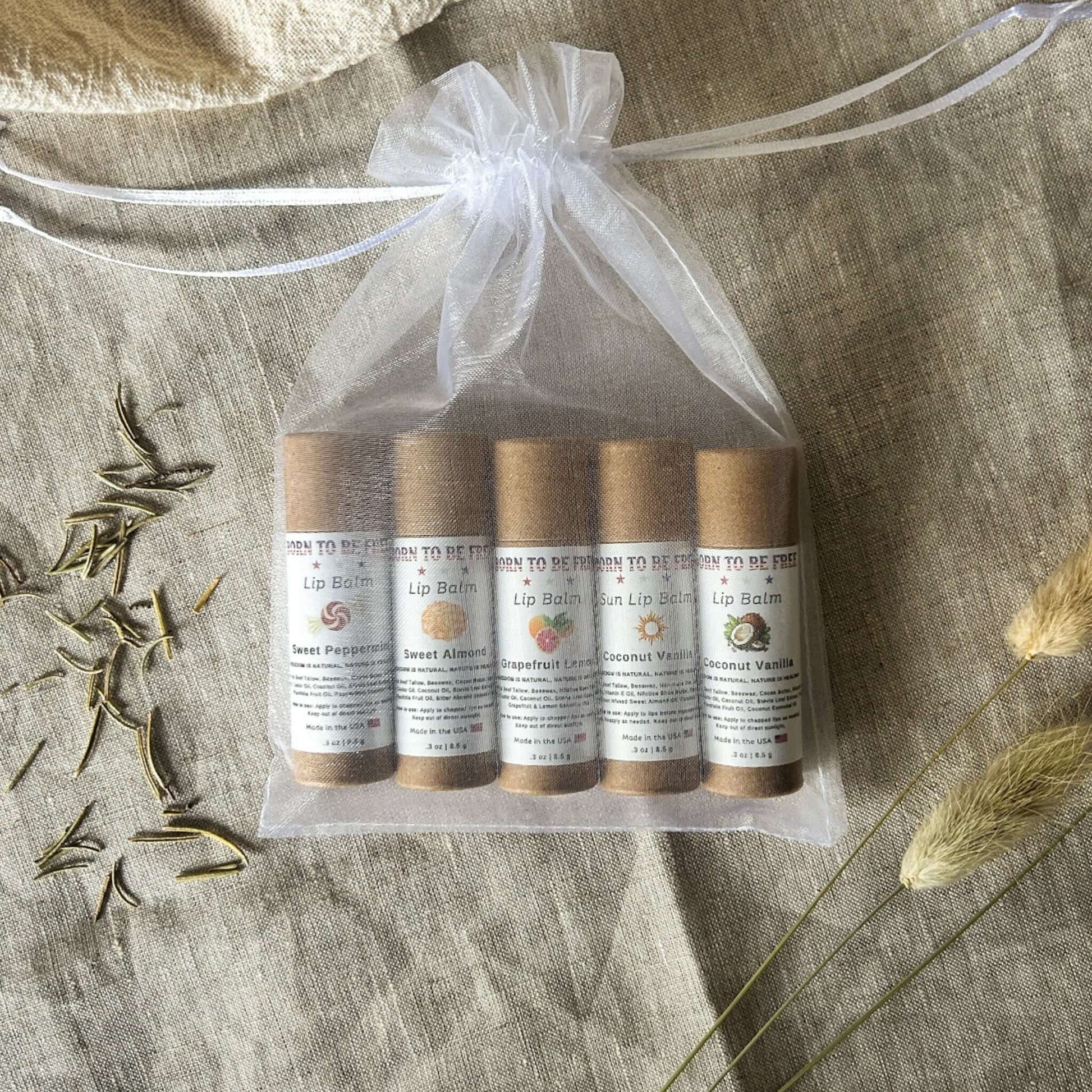 The Balm Bundle – Five all-natural lip balms in a drawstring bag with labels, including Sweet Peppermint and Coconut Vanilla.
