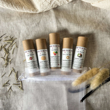 The Balm Bundle featuring five natural lip balms in eco-friendly packaging on a textured background.
